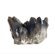 A cluster of dark smoky quartz crystals with a smoky appearance against a white background - JOY - Journey Of You - Spiritual, Holistic, Empowering