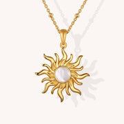 Gold sun-shaped pendant necklace on a white background