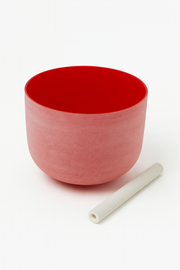 Red ceramic bowl with a white cylindrical object on a white background