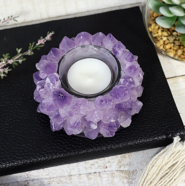 A candle holder made of hand-cut Amethyst crystals arranged in a lotus shape around a clear glass candle jar.