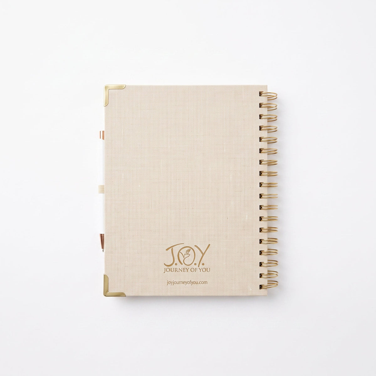 A beige linen-textured spiral notebook with gold metal corner protectors and a gold wire binding, featuring the 'Joy Journey of You' logo on the front cover, set against a clean white background.