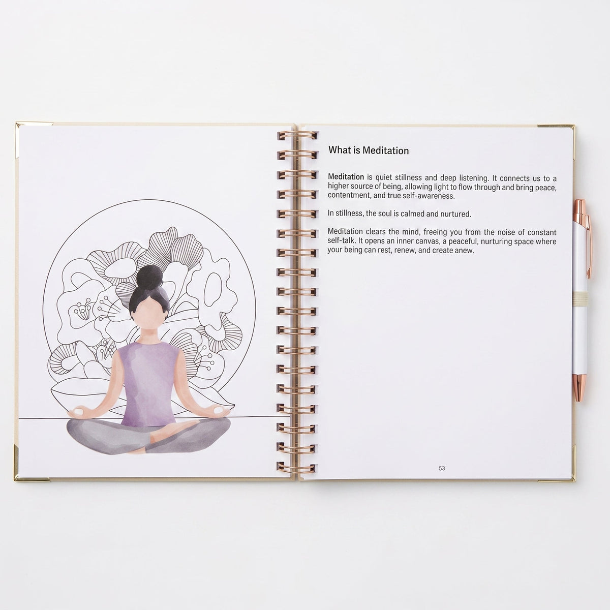 An open spiral-bound notebook on a white background, showing a meditation-themed page with text and an illustration of a seated figure inside a floral mandala. A metallic pen rests on the right side of the notebook.