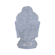 A carved clear quartz crystal in the shape of a Buddha head, with a translucent appearance.