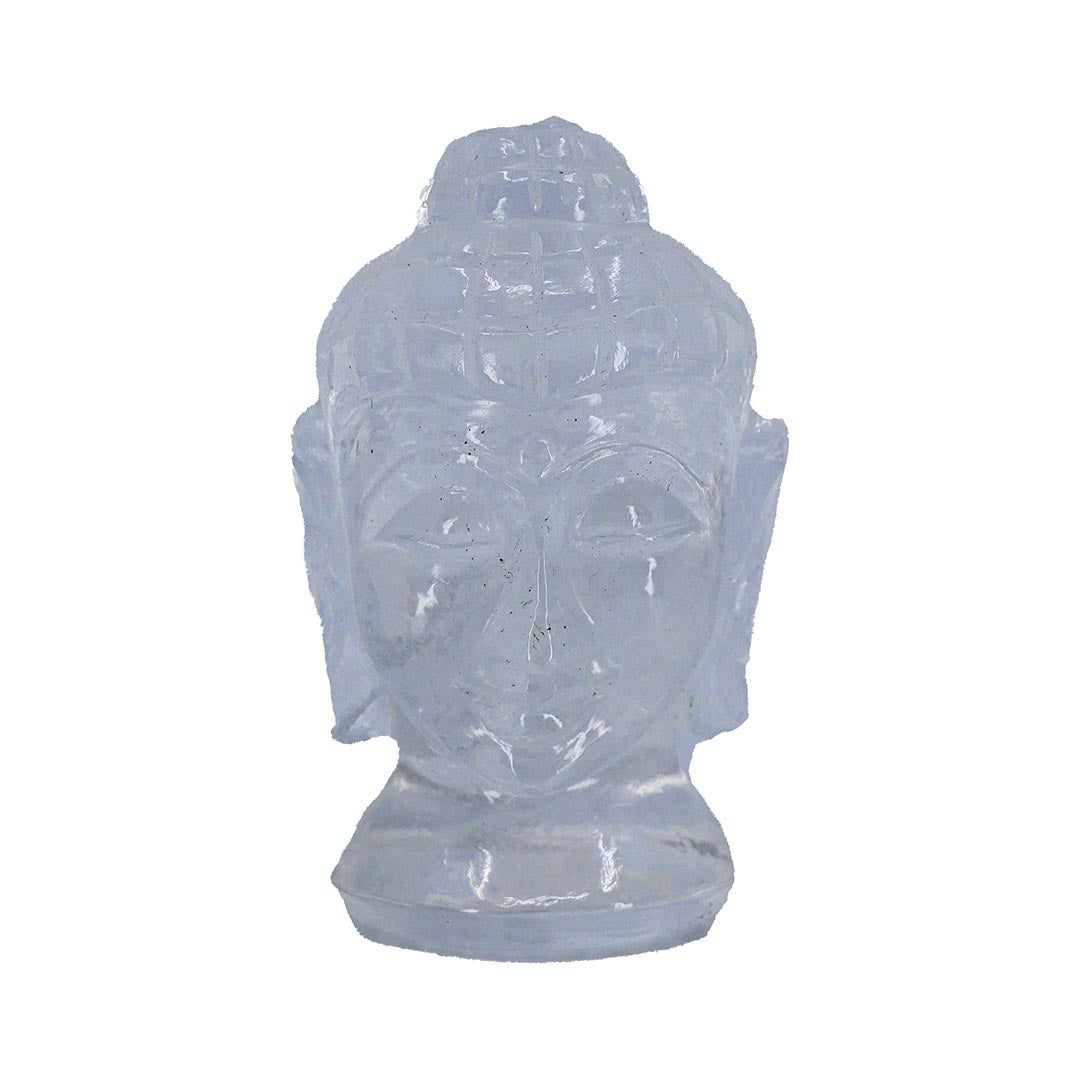 A carved clear quartz crystal in the shape of a Buddha head, with a translucent appearance.