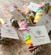 A collection of smudge sticks tied with colorful fabric, labeled 'Sacred Sunday' and 'Journey of You' - JOY - Journey Of You - Spiritual, Holistic, Empowering