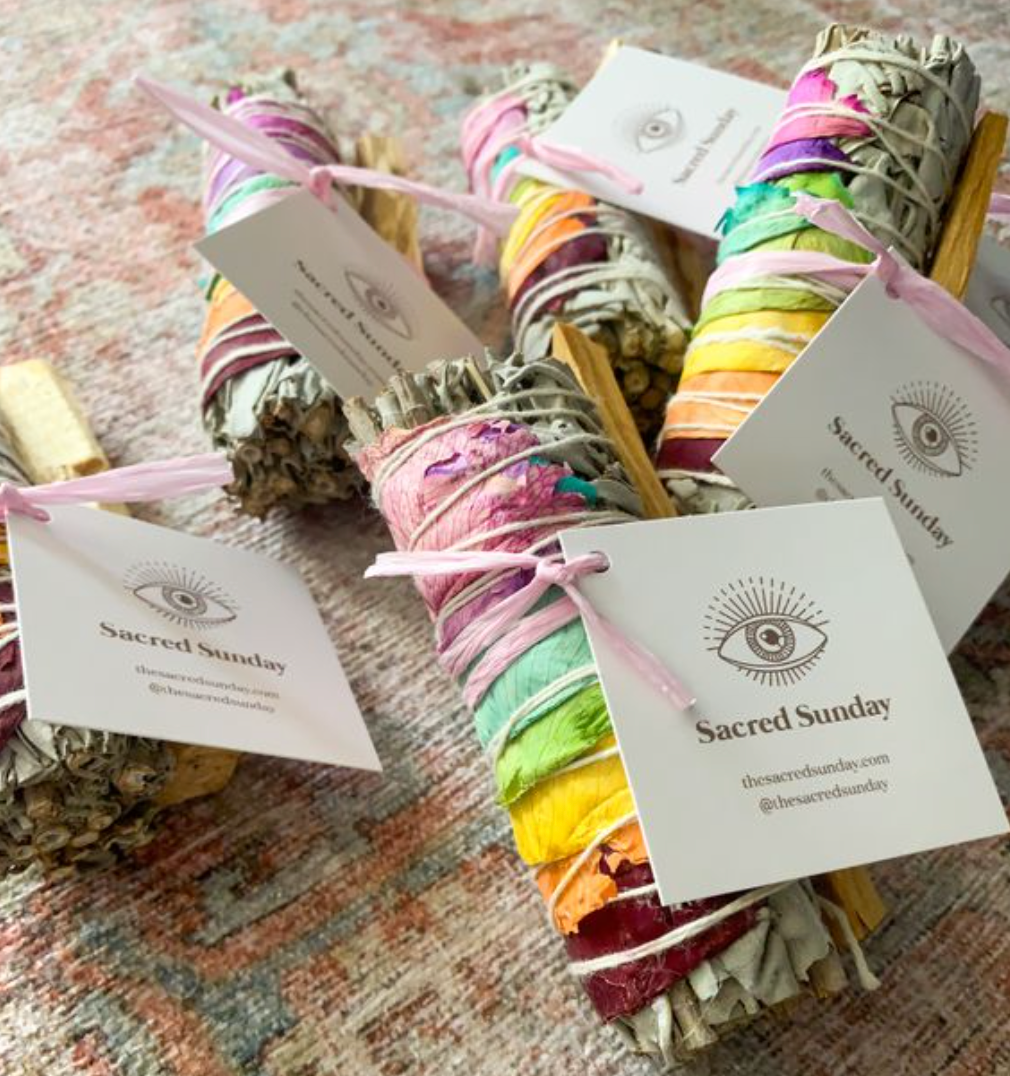 A collection of smudge sticks tied with colorful fabric, labeled 'Sacred Sunday' and 'Journey of You' - JOY - Journey Of You - Spiritual, Holistic, Empowering