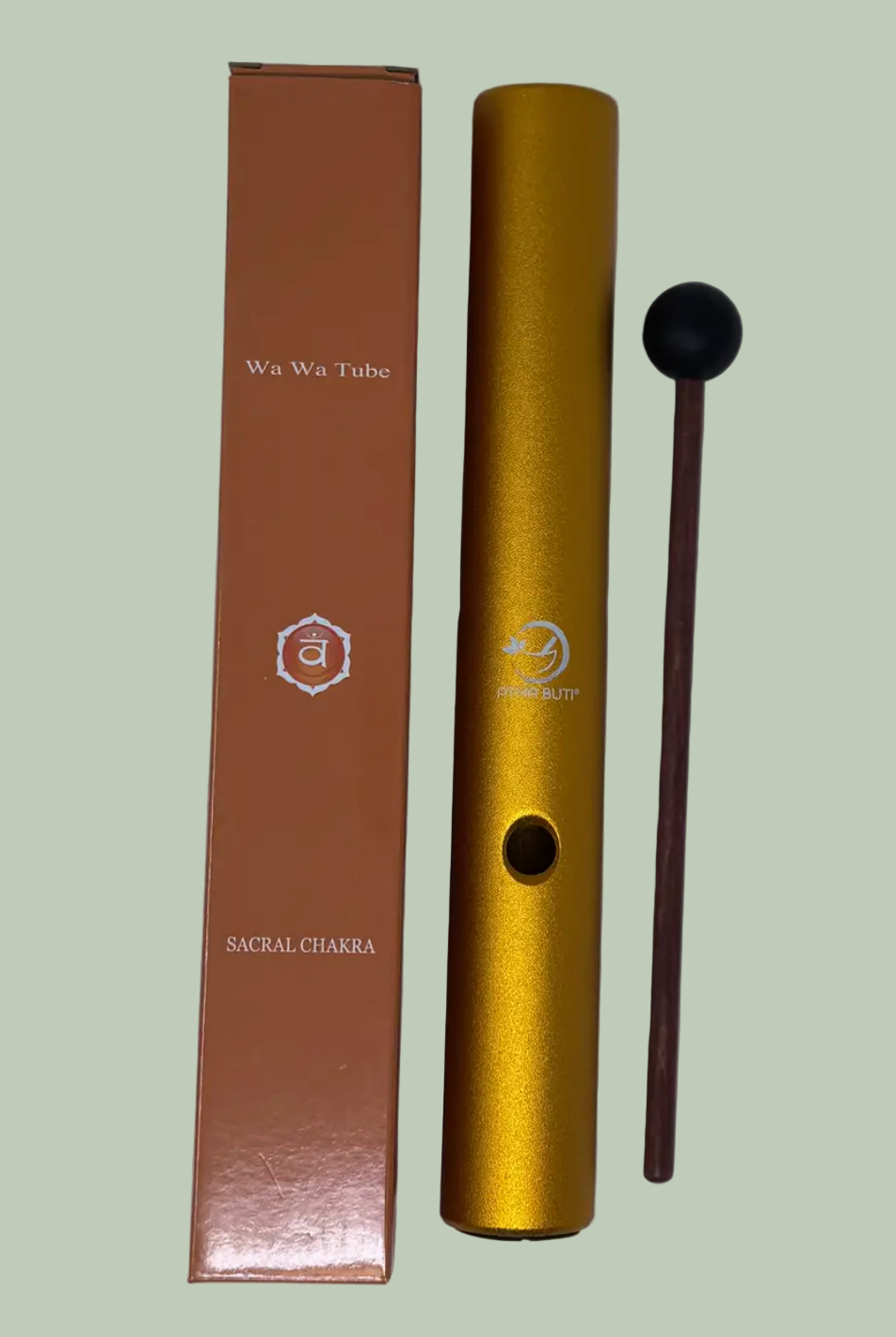 Gold tube with black end and brown packaging on a light green background