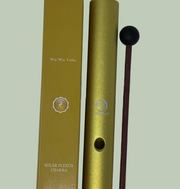 Gold tube with a mallet on a light gray background