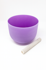 Purple singing bowl with a white stick on a white background